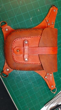A handcrafted hip bag featuring an orange metallic chrome tan body, hand-dyed veg-tan accents, and antique copper hardware.